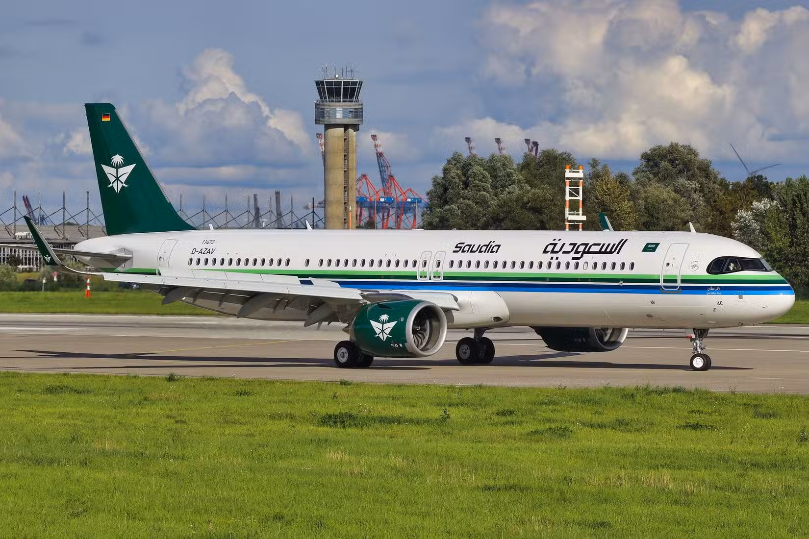Saudia Airbus A321 in green and gold livery in flight above clouds